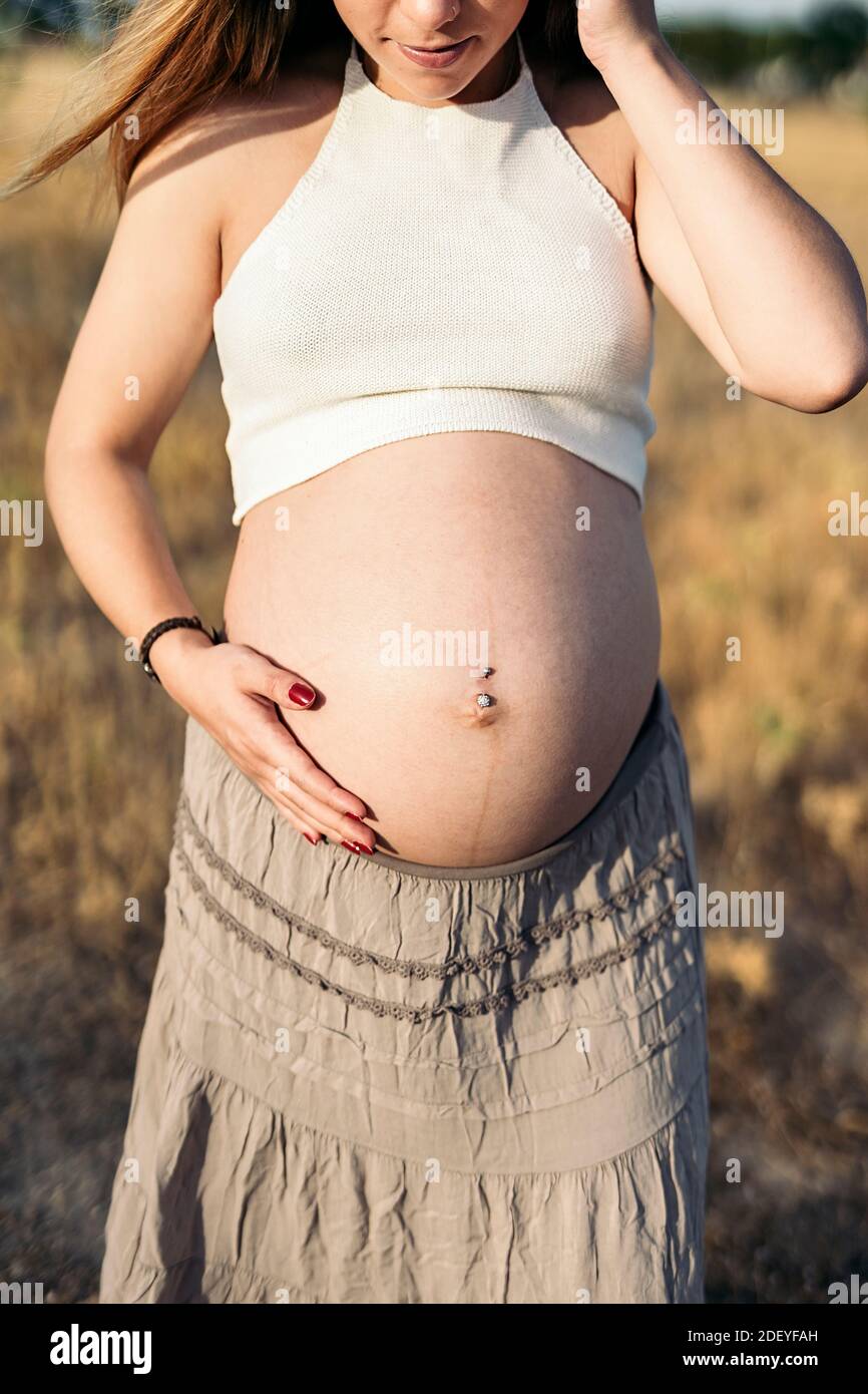 Foto di scorta di una donna incinta non riconosciuta che tocca il ventre. Foto Stock