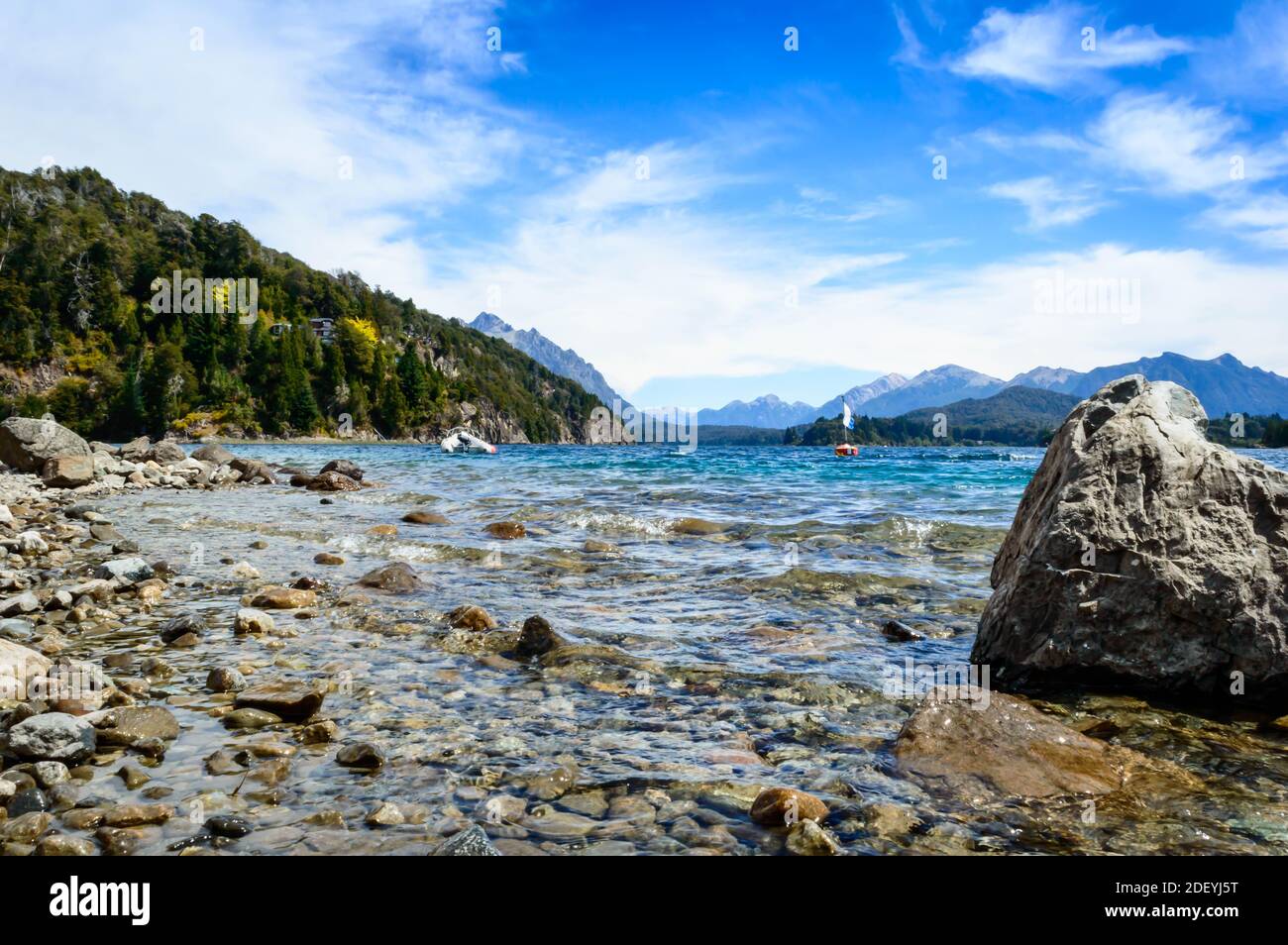 Attrezzatura subacquea sulle rocce su una spiaggia a Bariloche. Splendido paesaggio di rocce, acqua, montagne del lago e pini Foto Stock