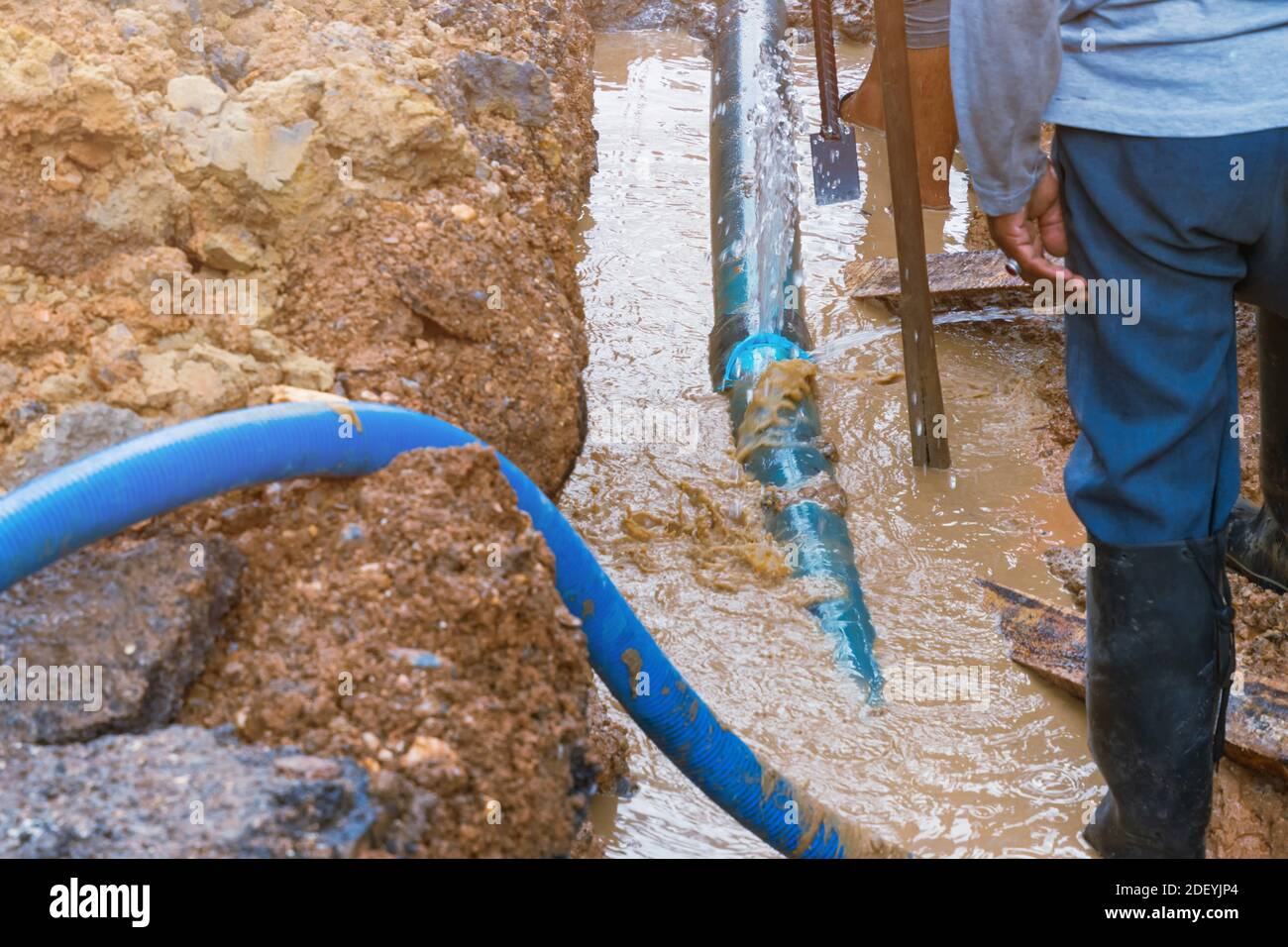 lavori idraulici, scavo, riparazione, tubazione dell'acqua, collegamento tubo principale in PVC impianto idraulico su strada e retroescavatore (movimento dell'acqua) Foto Stock