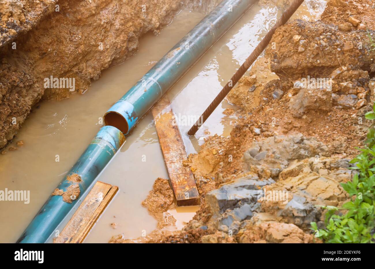 riparare la tubazione rotta e il flusso d'acqua nel foro Foto Stock