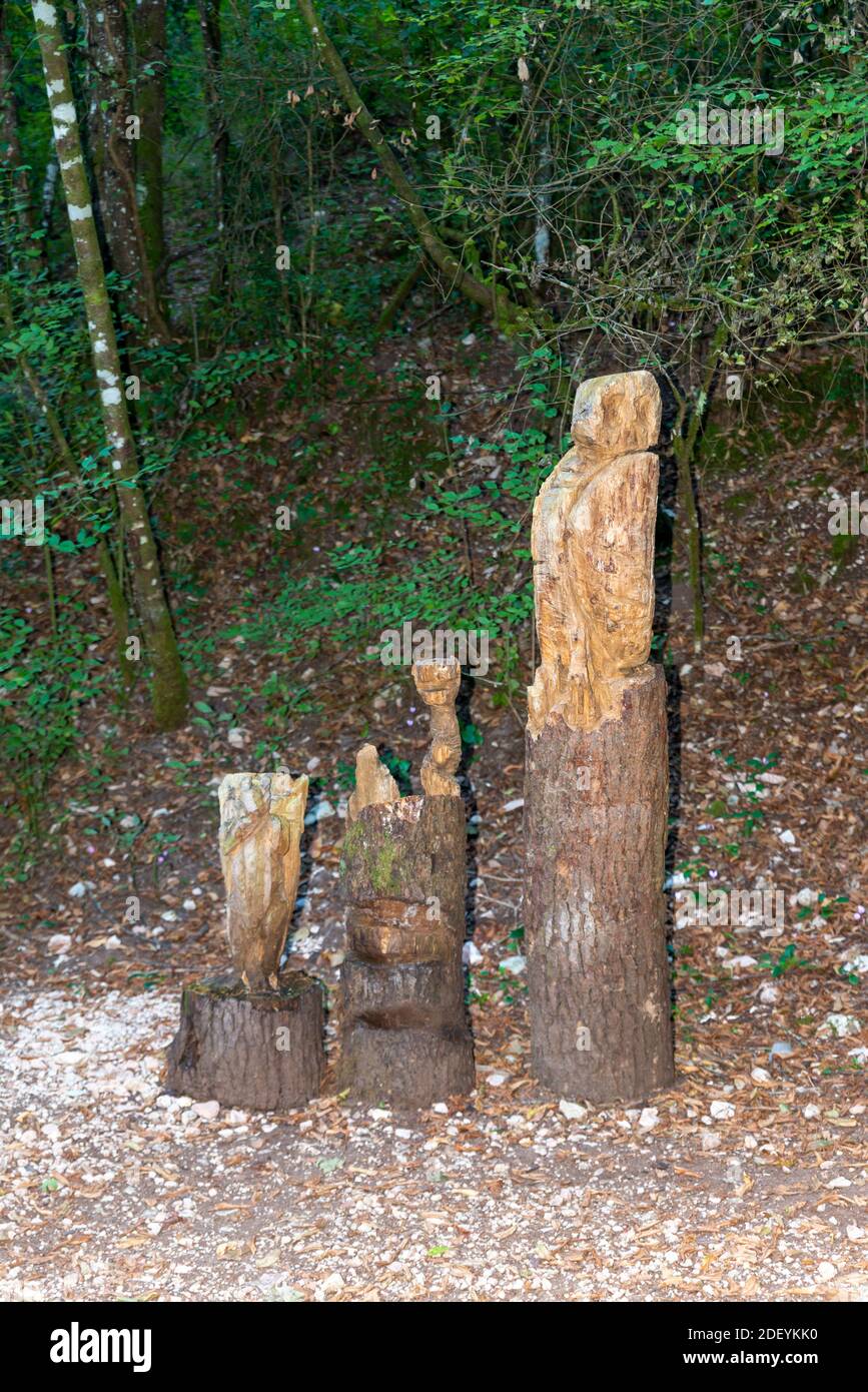 totem in legno intarsiato a forma di gufo posizionato nei boschi Foto Stock