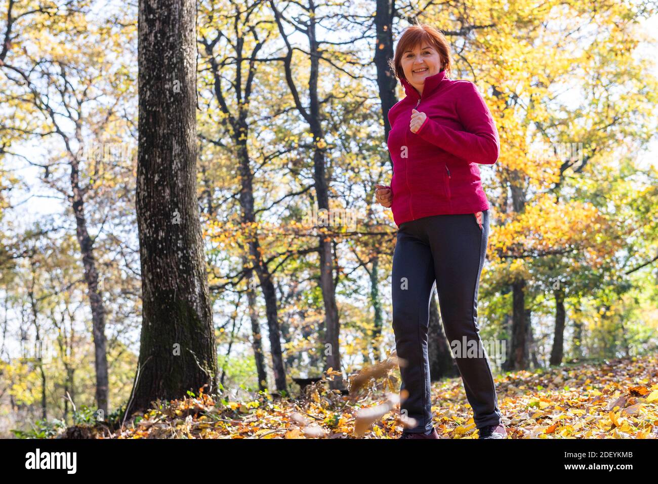 active midle aged woman jogs corre Foto Stock