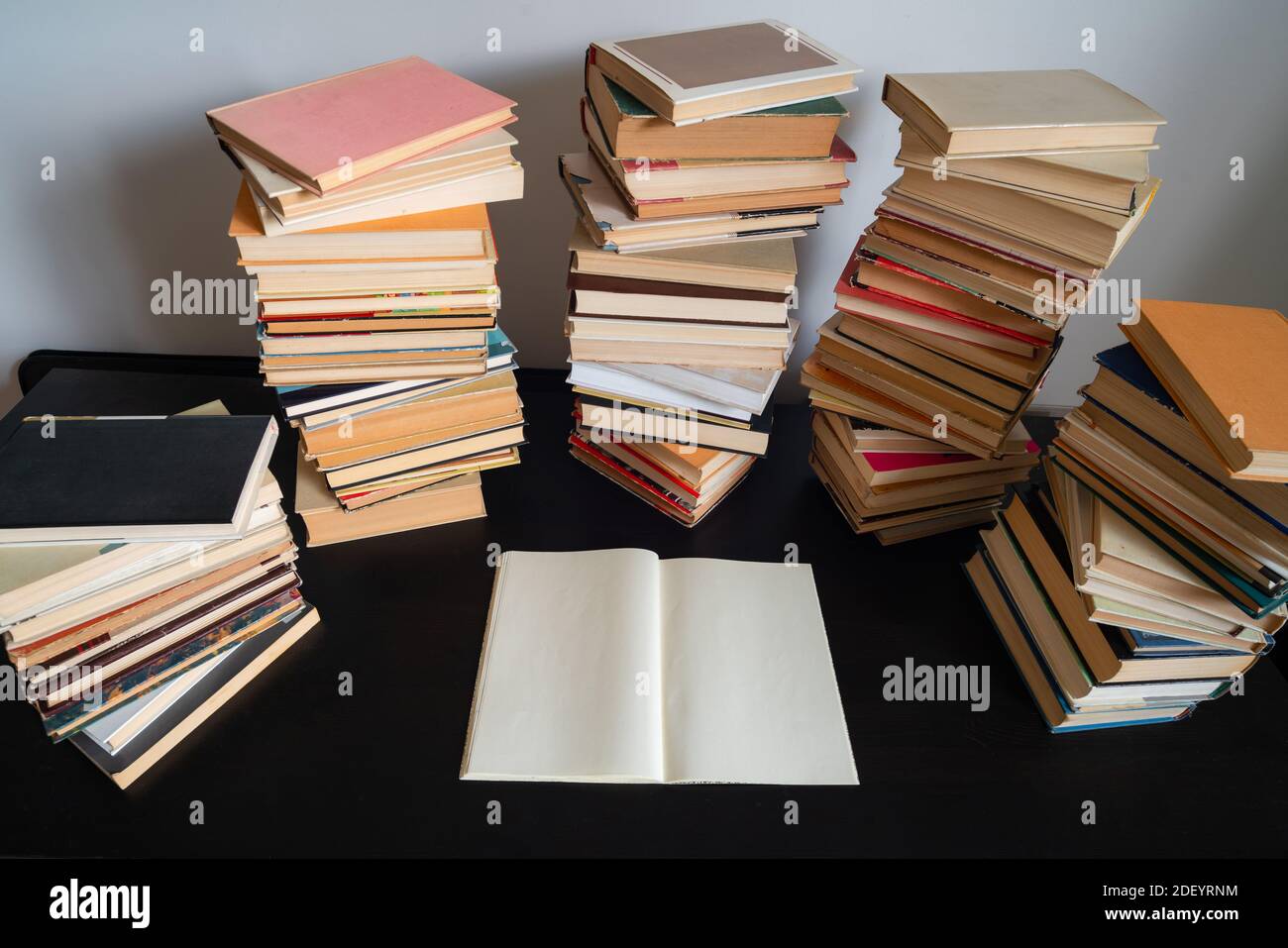 Grande pila di libri sul tavolo. Studiare prima dell'esame. Pila di libri d'epoca. Concetto di istruzione e di studio Foto Stock