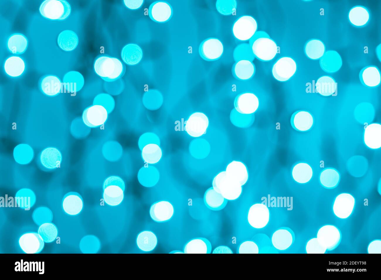Bokeh blu ciano LED illuminazione astratta sfondo sfocato. Luci blu sfocate di una ghirlanda elettrica. Decorazione ed elemento di design per le vacanze. Foto Stock