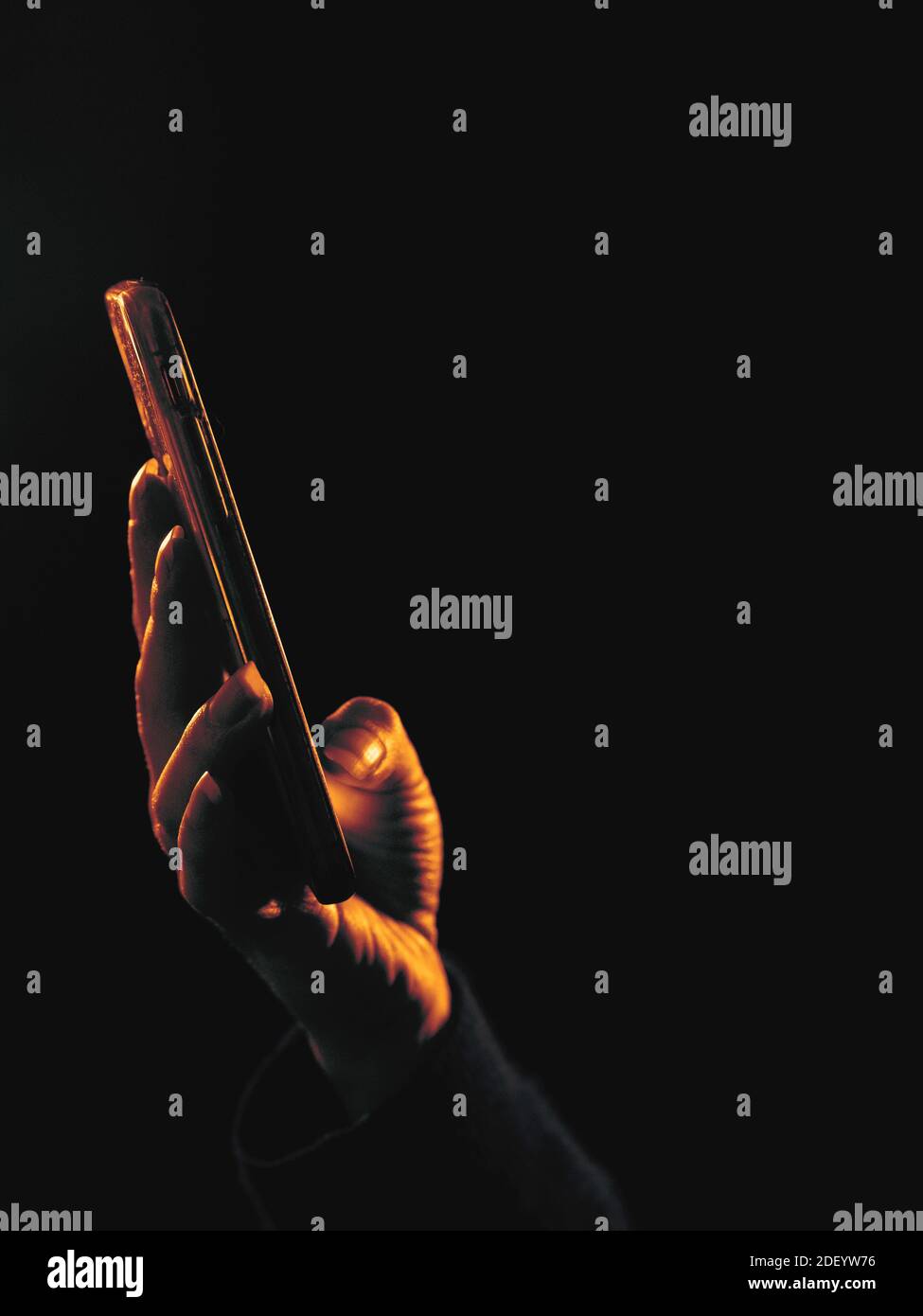 donna che naviga sul suo telefono in condizioni di scarsa illuminazione Foto Stock