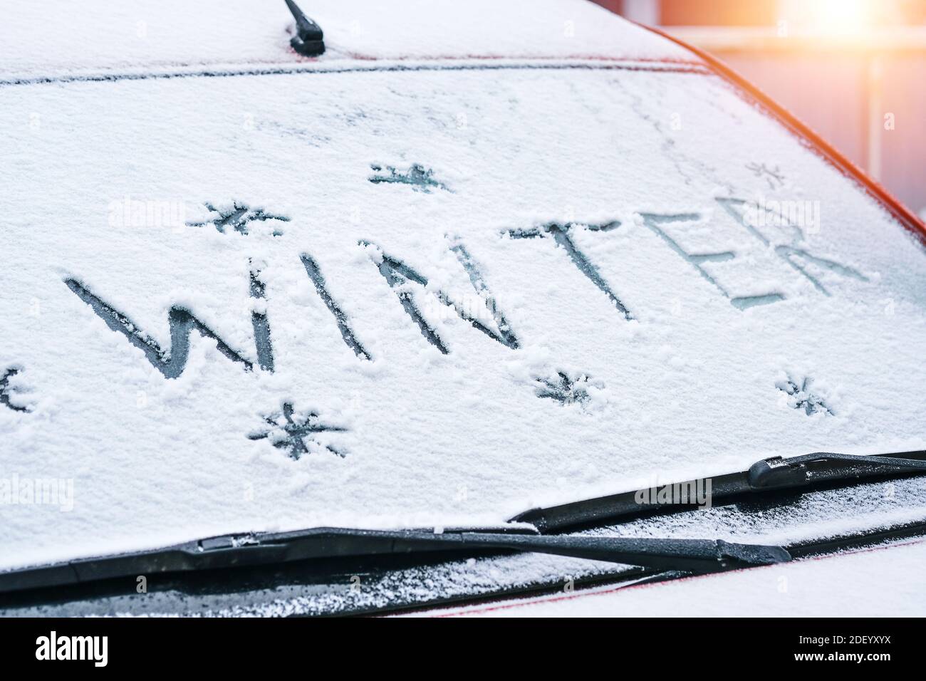 Parola Inverno scritto con il dito su un parabrezza nevoso di una macchina Foto Stock
