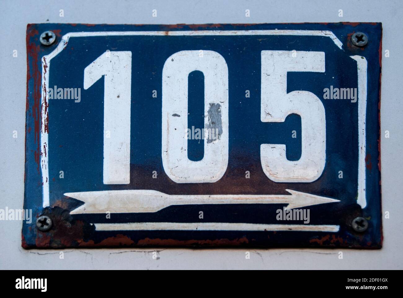 Grunge pialla quadrata in metallo smaltato con agenti atmosferici del numero di strada indirizzo con numero 105 Foto Stock