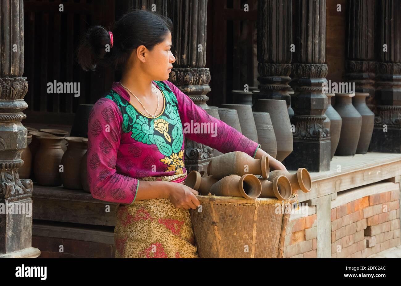 Donna che trasporta la ceramica nel cestino, Piazza della ceramica, Bhaktapur, Nepal Foto Stock