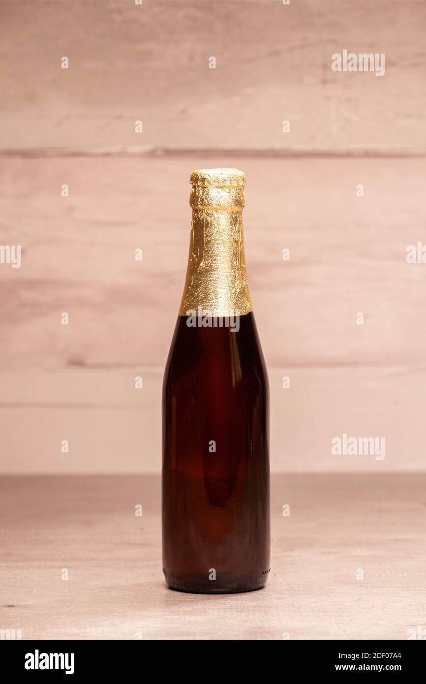 Una bottiglia di birra bionda con carta oro Foto Stock