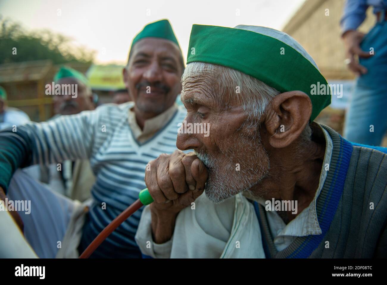 Un agricoltore di 97 anni, Swarna Singh fuma hookah durante la manifestazione.migliaia di agricoltori provenienti da vari stati marciano verso la capitale indiana per protestare contro le nuove leggi agricole che dicono di danneggiare gravemente i loro redditi, secondo l'Unione dei coltivatori. Foto Stock