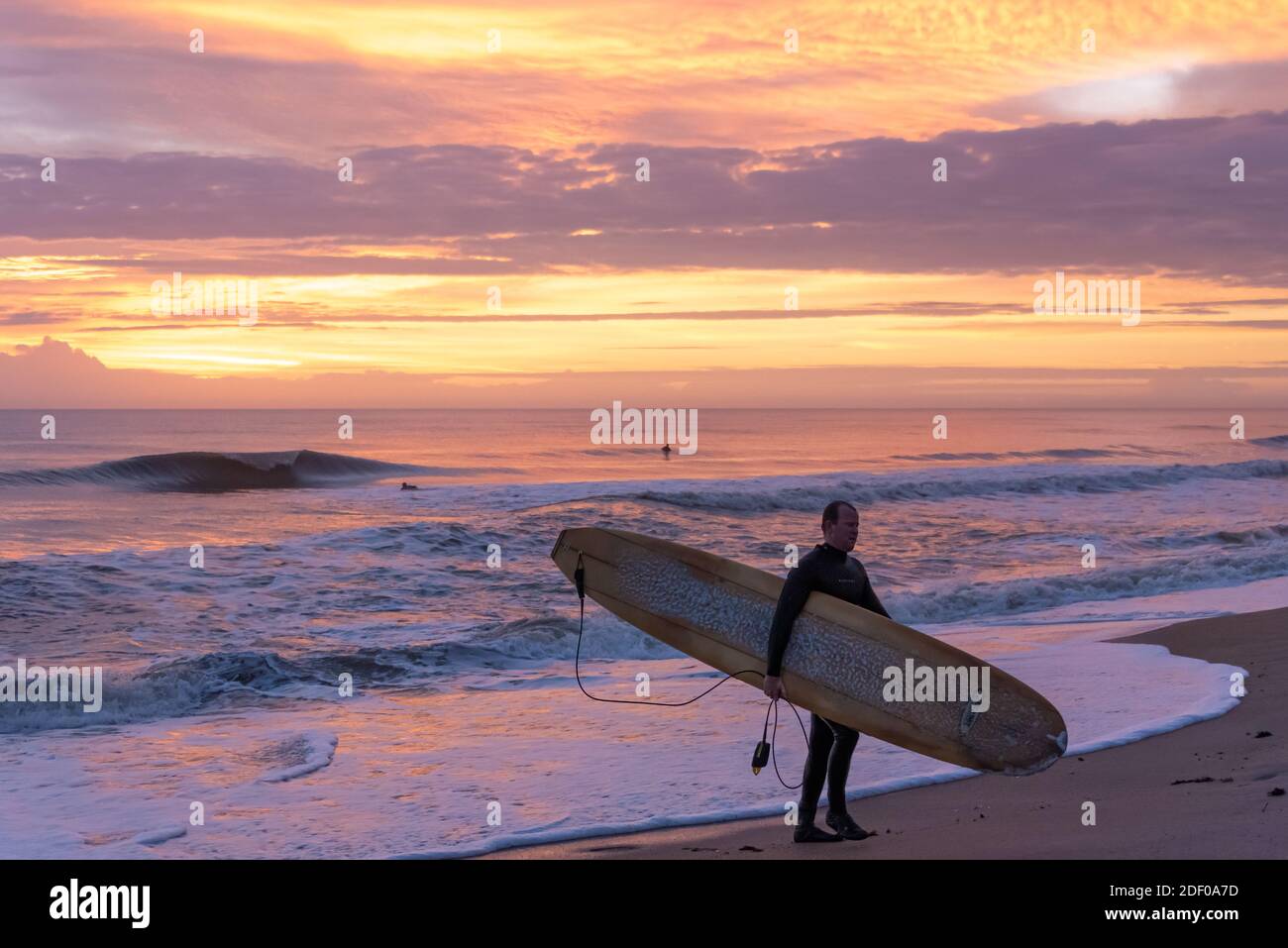 Surfista della Florida con longboard sulla spiaggia dopo una sessione di surf prima dell'alba al Mickler's Landing a Ponte Vedra Beach, Florida. (STATI UNITI) Foto Stock