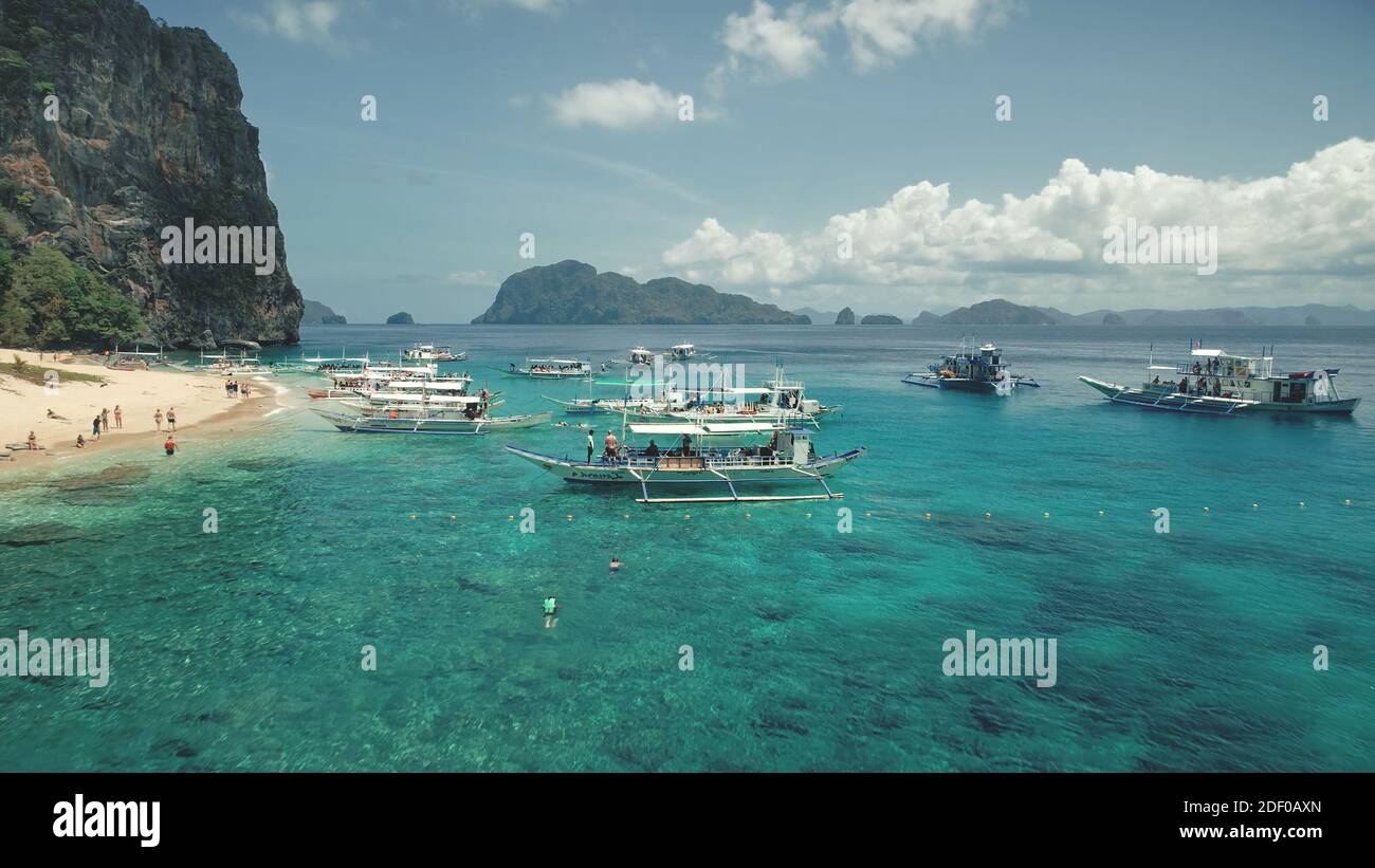 Barche a vela sul sereno mare presso la verde isola montuosa di Palawan, Filippine. Meravigliosa nessuna natura di disabitata, isola desertica dell'Arcipelago di Visayas. Turismo estivo sulle navi del golfo di mare Foto Stock