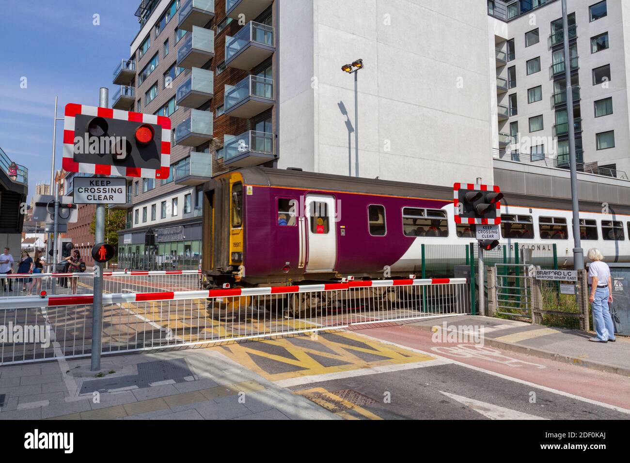 Treno che passa attraverso una traversata a livello vicino al campus della Brayford Pool della University of Lincoln, Brayford Pool, Lincoln, Lincolnshire, Regno Unito. Foto Stock