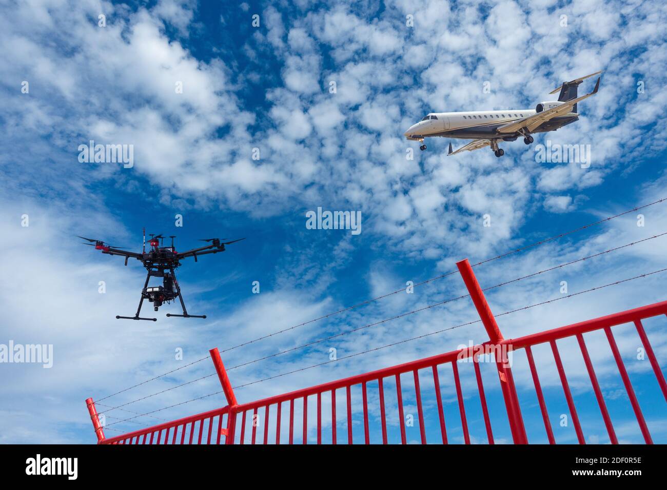 Embraer ERJ-135BJ Legacy 600 atterraggio privato in aeroporto con drone che sorvola il perimetro dell'aeroporto, recinzione di sicurezza. Drone, droni, spazio aereo, concetto Foto Stock