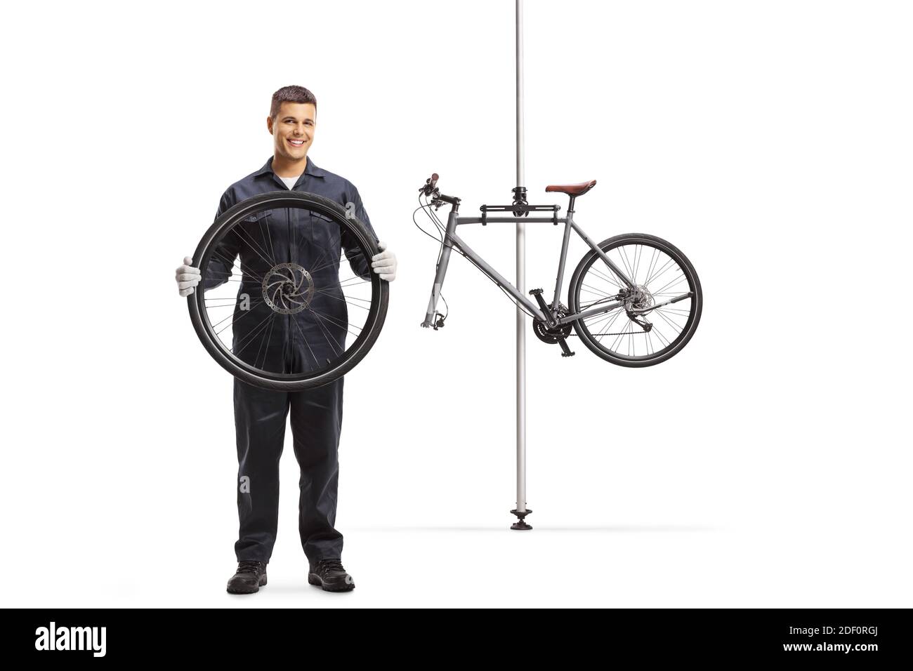 Riparatore di biciclette con una ruota e una bicicletta per la riparazione appeso su un supporto isolato su sfondo bianco Foto Stock