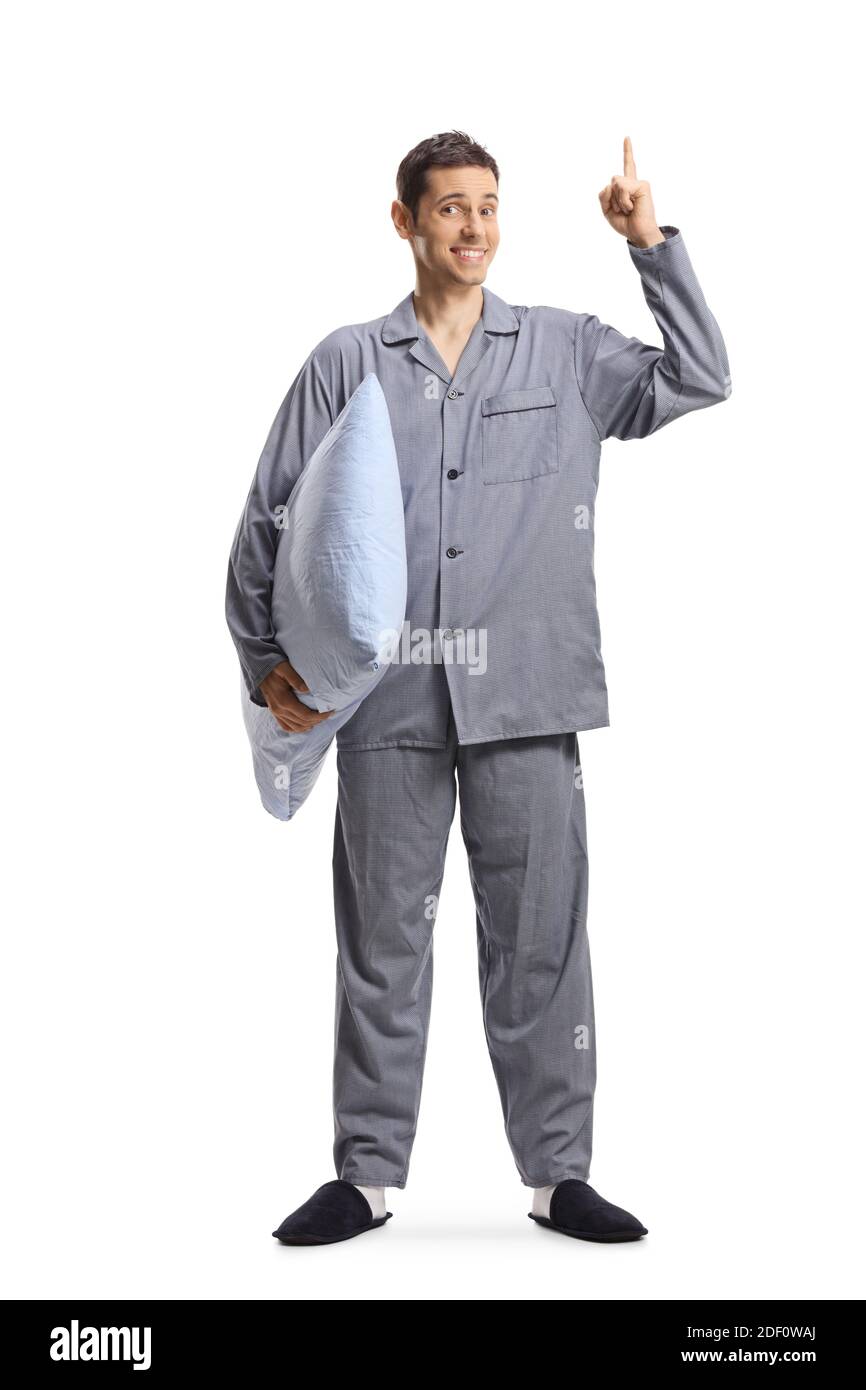 Ritratto a lunghezza intera di un uomo in pigiama che tiene un cuscino e rivolto verso l'alto isolato su sfondo bianco Foto Stock