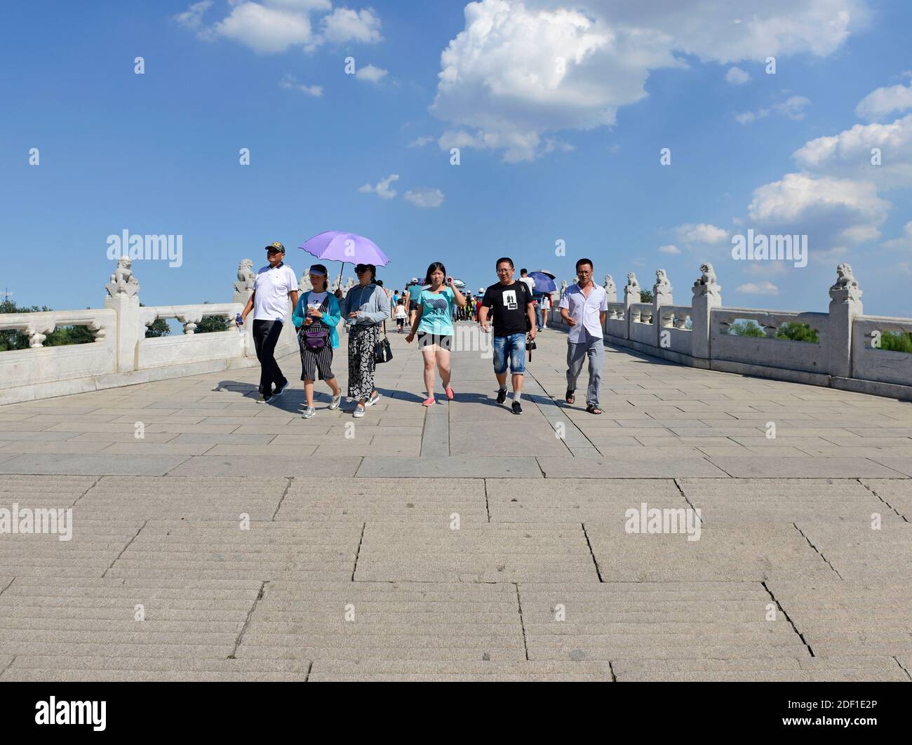 I visitatori attraversano il ponte a diciassette archi presso il Palazzo Estivo nella parte nord-occidentale di Pechino, Chia Foto Stock
