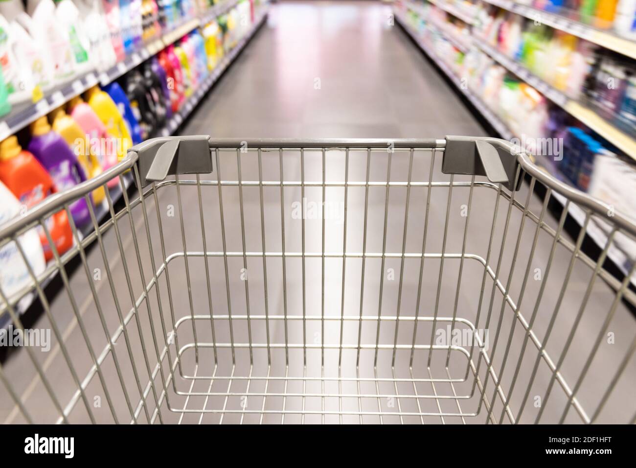 Carrello carrello di shopping che si muove in supermercato con movimento blur corsia sfondo Foto Stock