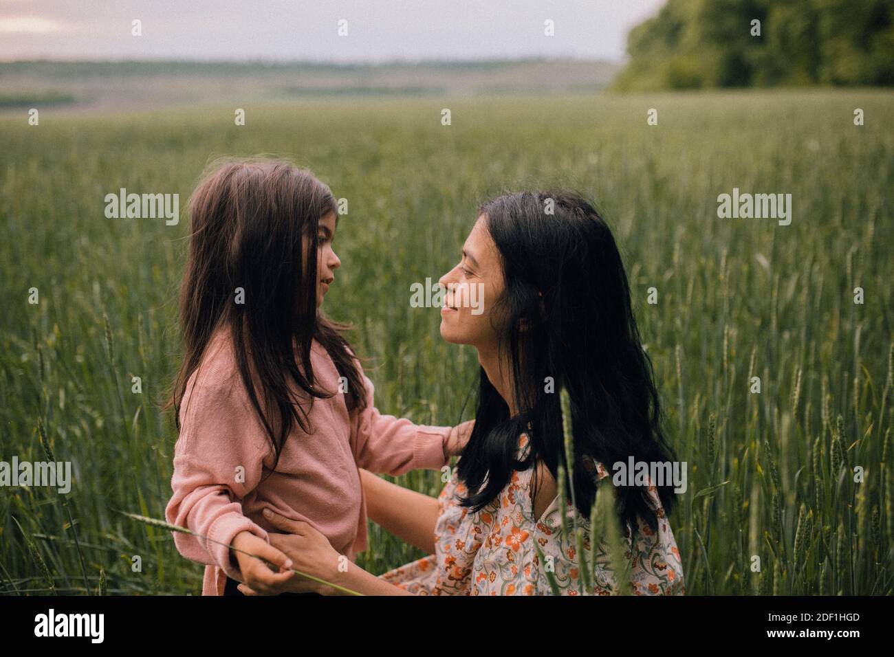 Sorridendo madre e figlia e parlando sul campo Foto Stock