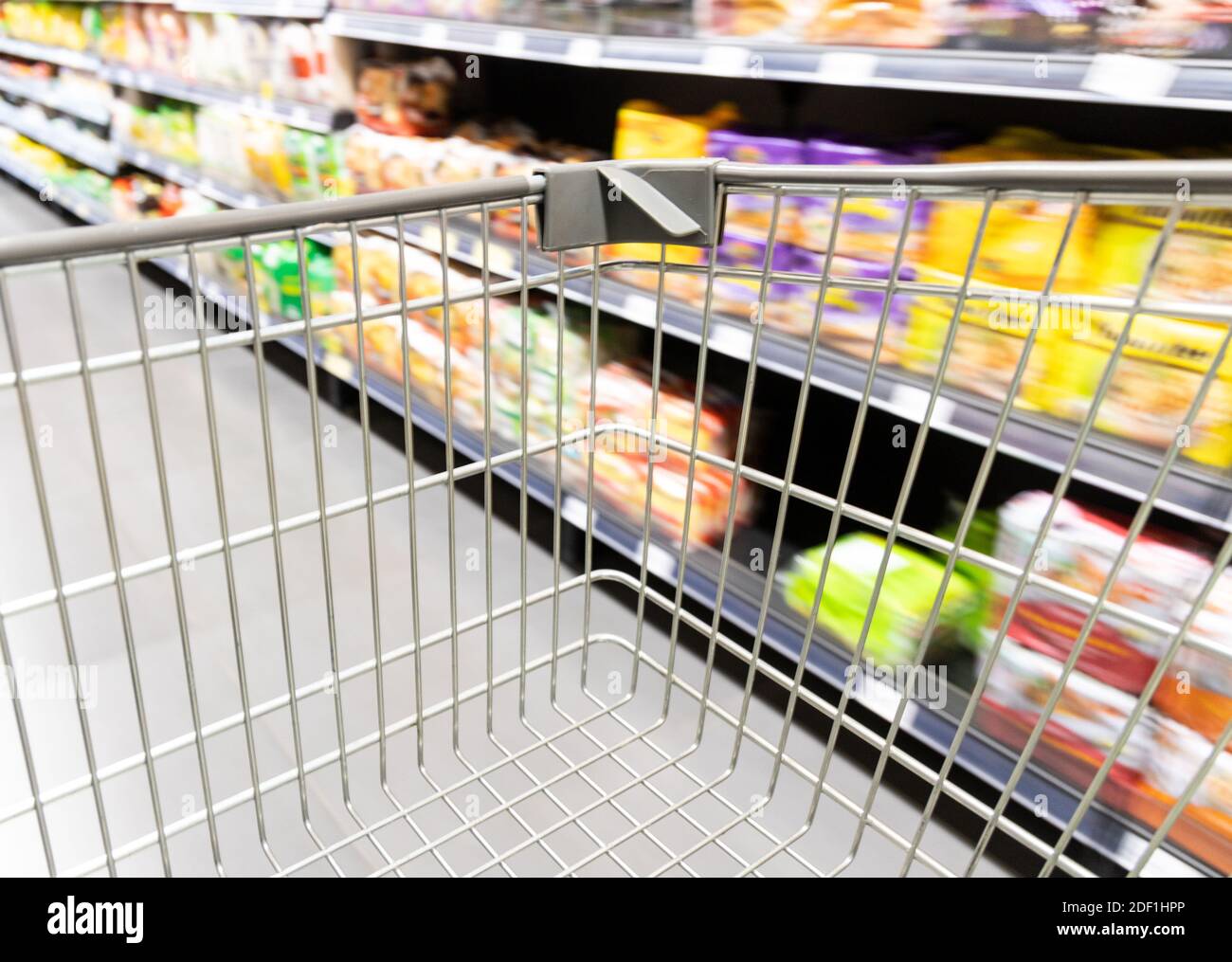 Carrello carrello di shopping che si muove in supermercato con movimento blur corsia sfondo Foto Stock