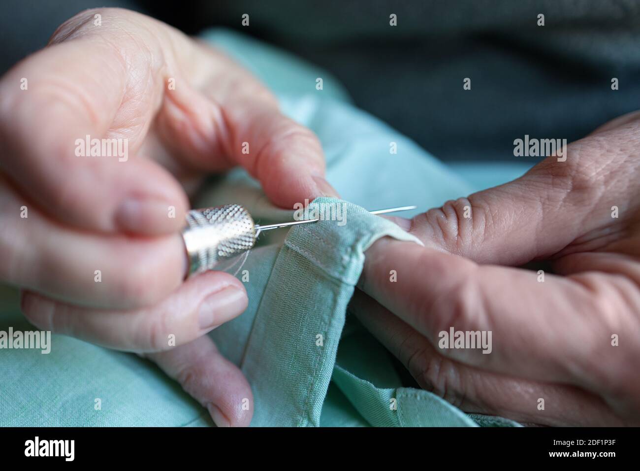 Primo piano di una vecchia donna cucita a casa Foto Stock