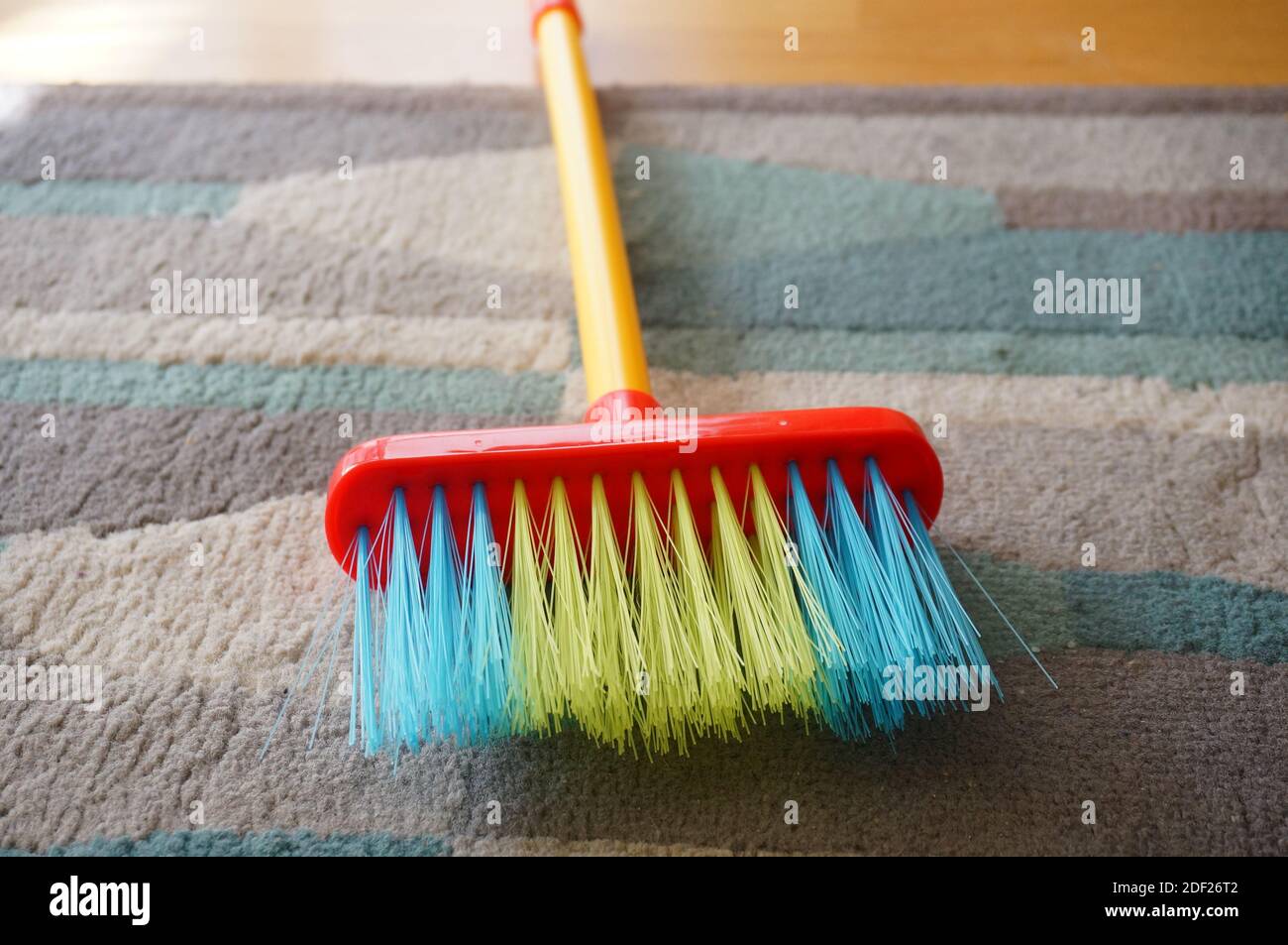 Pulizia tappeto con piccola scopa e paletta rossa Foto stock - Alamy