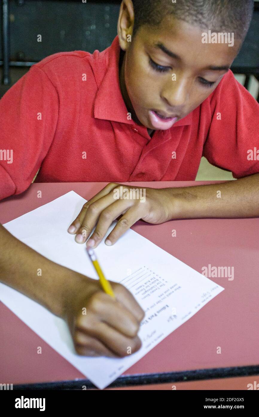 Miami Florida,Little Haiti Edison Park Elementary School,studenti studenti Black African ragazzo ragazzi scrittura, Foto Stock