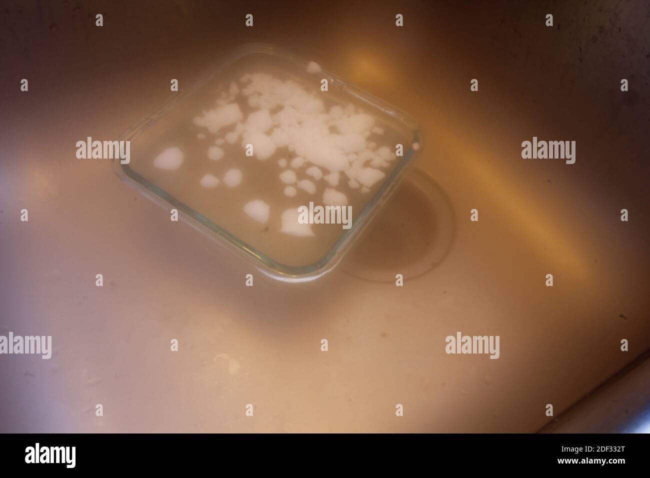 Ghiaccio secco in una ciotola di acqua in un sink Foto Stock