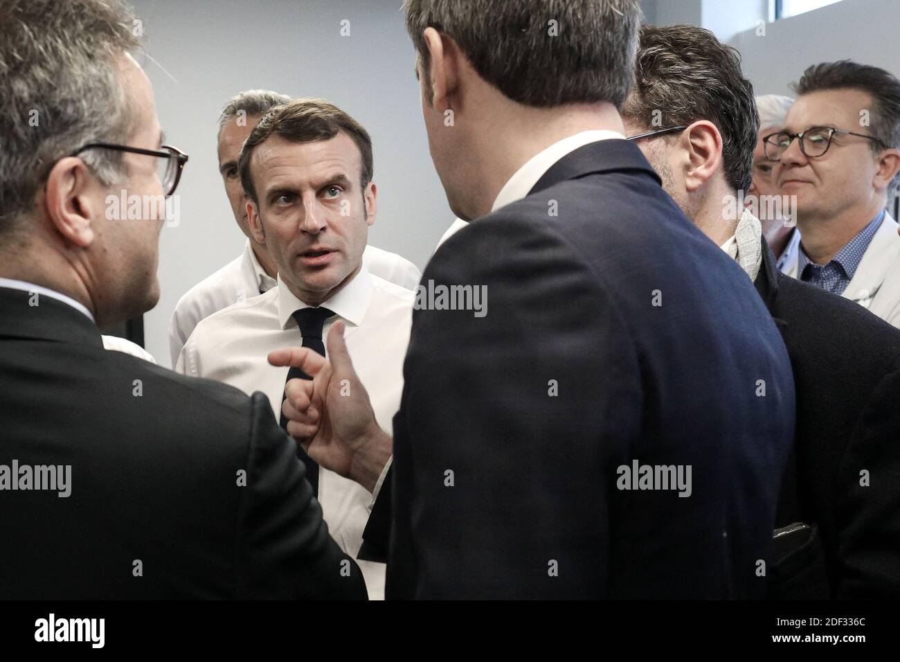 Il presidente francese Emmanuel Macron, affiancato dal presidente AP-HP Martin Hirsch e dal ministro francese della Sanità Olivier Veran, incontra il personale medico mentre visita l'ospedale di Pitie-Sampetriere a Parigi il 27 febbraio 2020, dove la prima vittima francese della COVID-19 è scomparsa il giorno prima. La Francia ha finora registrato 18 infezioni e due decessi, un cittadino francese di 60 anni e un turista cinese di 80 anni, mentre i governi europei si sforzano di contenere una serie di nuovi casi di coronavirus che si sono verificati in tutto il continente. Foto di Stephane Lemouton/ABACAPRESS.COM Foto Stock