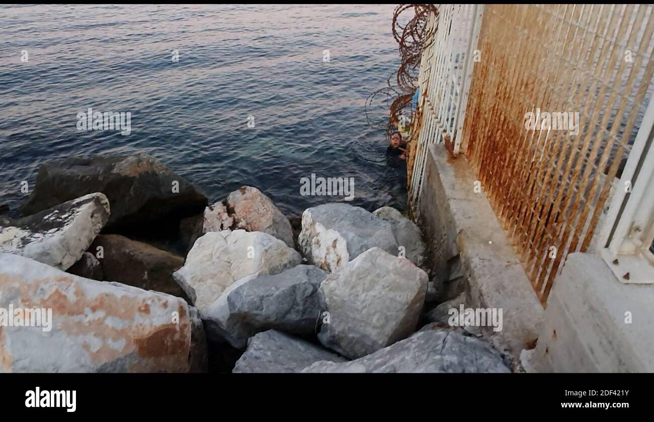 Scappatoia per i rifugiati in fuga da una nave militare della Marina greca che serve da rifugio temporaneo per 400 a 600 migranti arrivati dall'inizio di marzo nel porto di Mutilene sull'isola di Lesbos; A seguito della decisione della Turchia di aprire le sue frontiere e della decisione della Grecia di interrompere la registrazione di nuove domande di asilo. Di conseguenza, questi migranti non sono registrati, in disparte dalle regole internazionali, e temono di essere deportati in Turchia. Senza registrazione non hanno alcuna esistenza legale: Il 15 marzo 2020, alcuni di loro hanno approfittato di un movimento di folla per tentare la fortuna. Loro Foto Stock