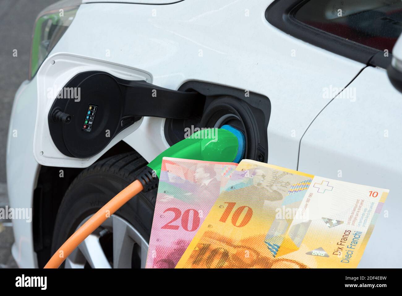 Un'auto elettrica e banconote in franchi svizzeri Foto Stock