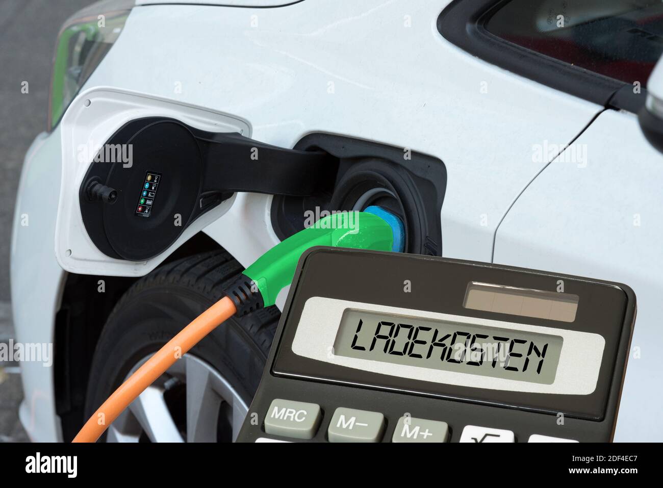 Un'auto elettrica, una calcolatrice e si carica per la ricarica Foto Stock