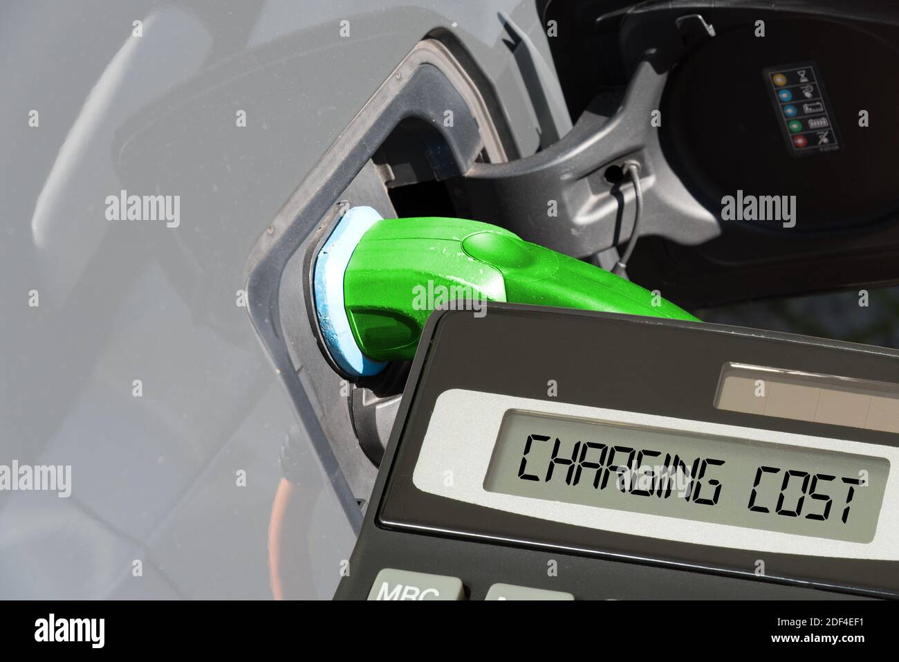 Un'auto elettrica, una calcolatrice e si carica per la ricarica della batteria Foto Stock