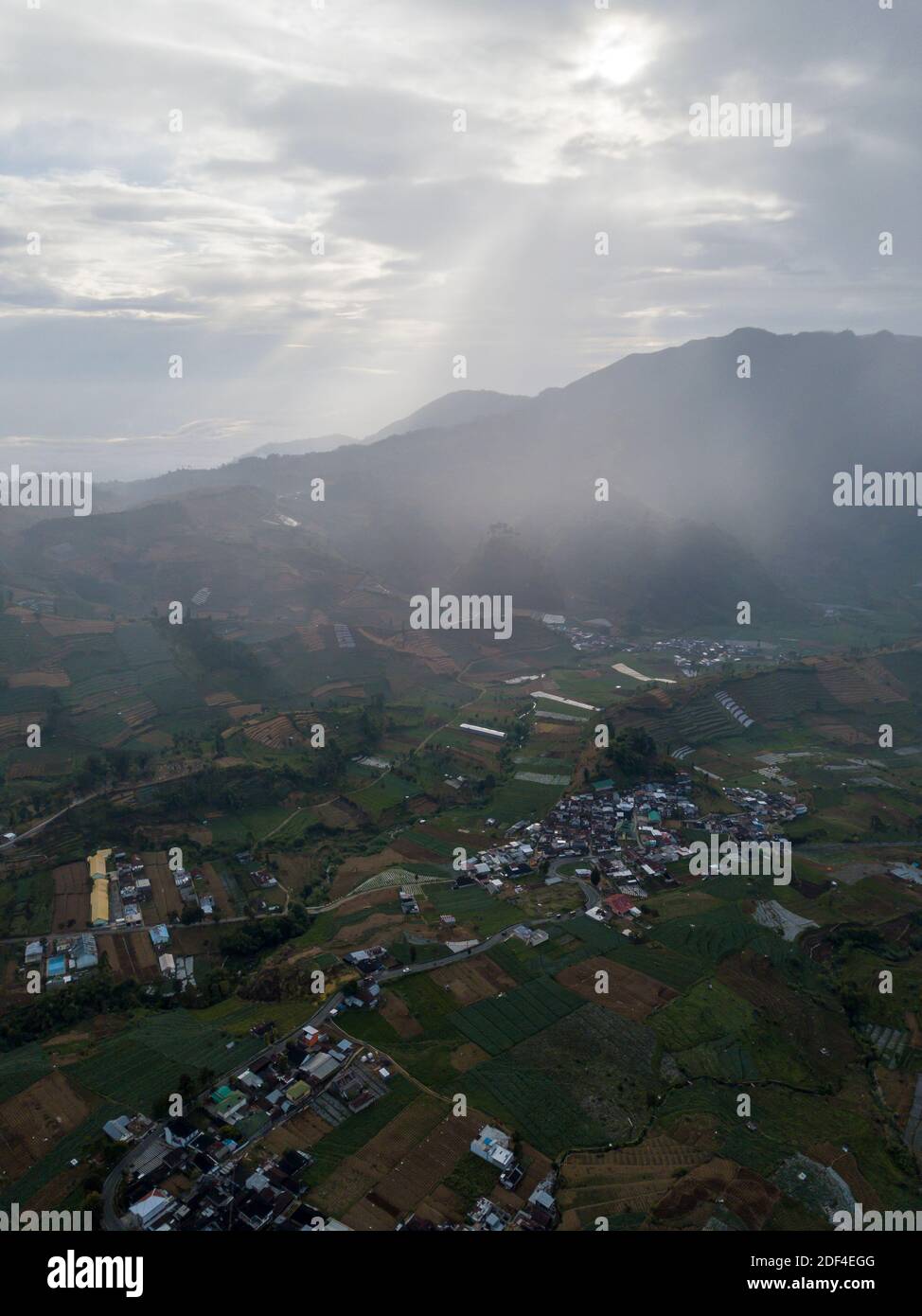 Vista aerea di un villaggio nell'altopiano di Dieng, Indonesia. Vista mattutina della campagna tra le montagne Foto Stock