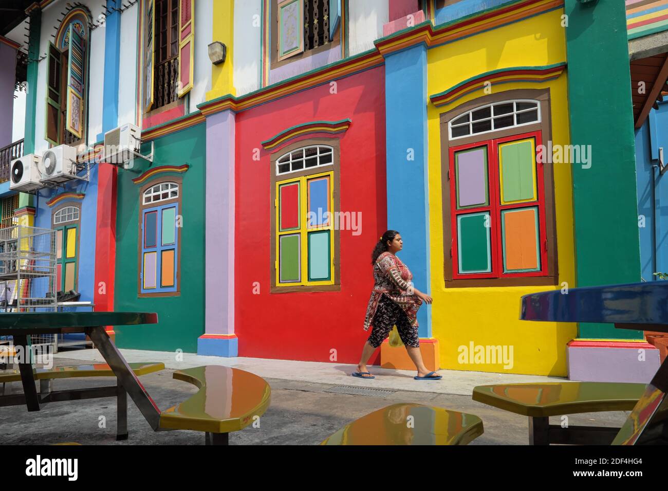 Una donna che cammina per la Casa multicolore di Tan Teng Niah, una ex villa del commerciante in Little India, Singapore Foto Stock