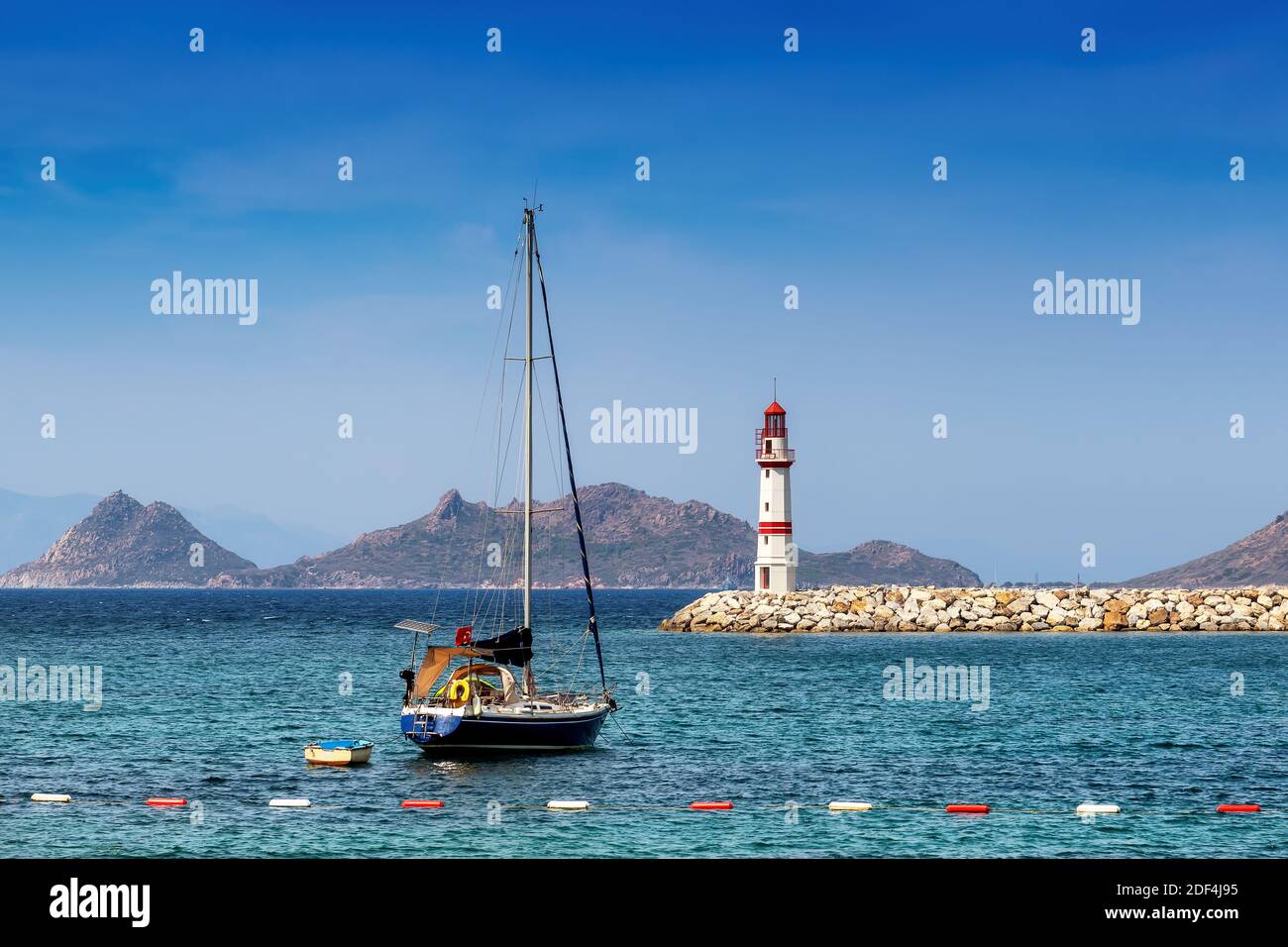 Faro e barche a vela in porto e isole nel Mar Mediterraneo. Foto Stock