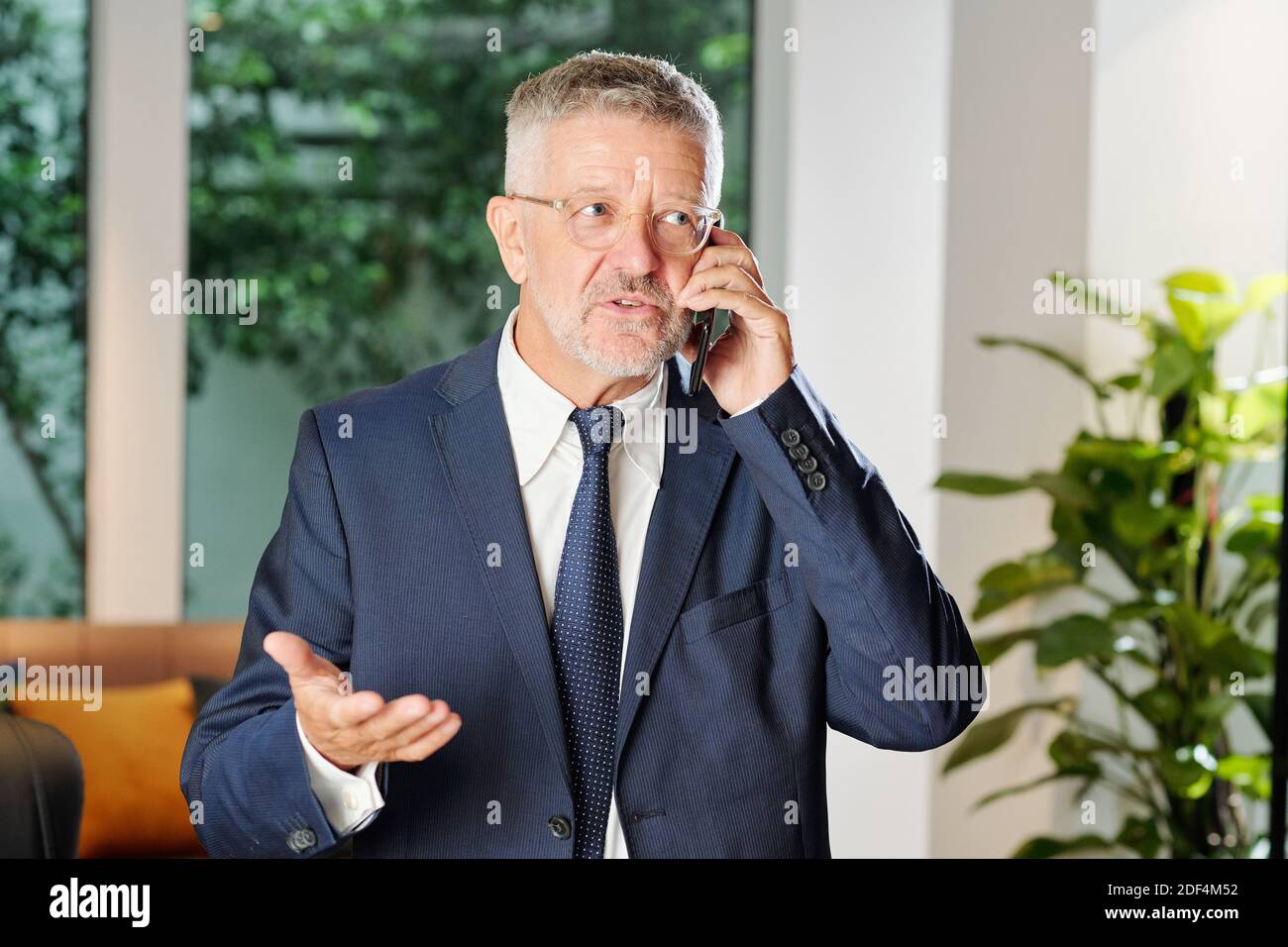 Imprenditore maturo che chiama al telefono Foto Stock