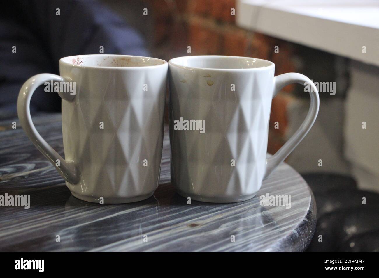 Due caffè espresso in piccole tazze bianche sul tavolo grigio in legno del caffè. Amore e concetto di relazione Foto Stock