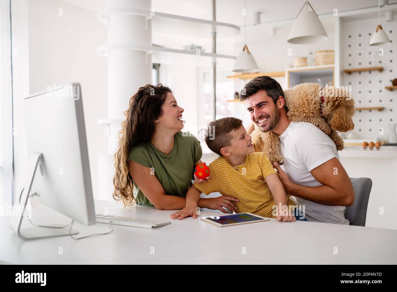 Felice famiglia con i dispositivi moderni e cane divertirsi, giocando a casa Foto Stock