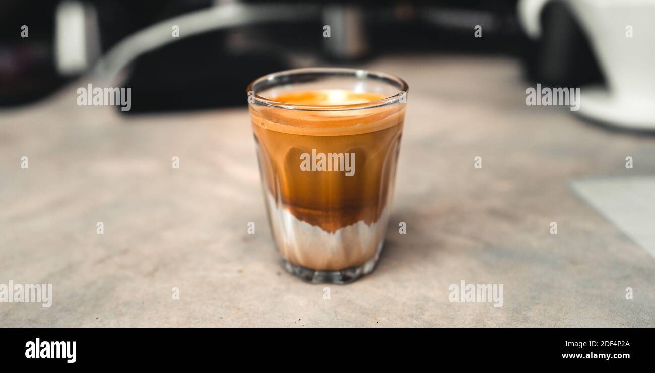 Caffè caldo, caffè e latte in un bicchiere mettere su bar Foto Stock