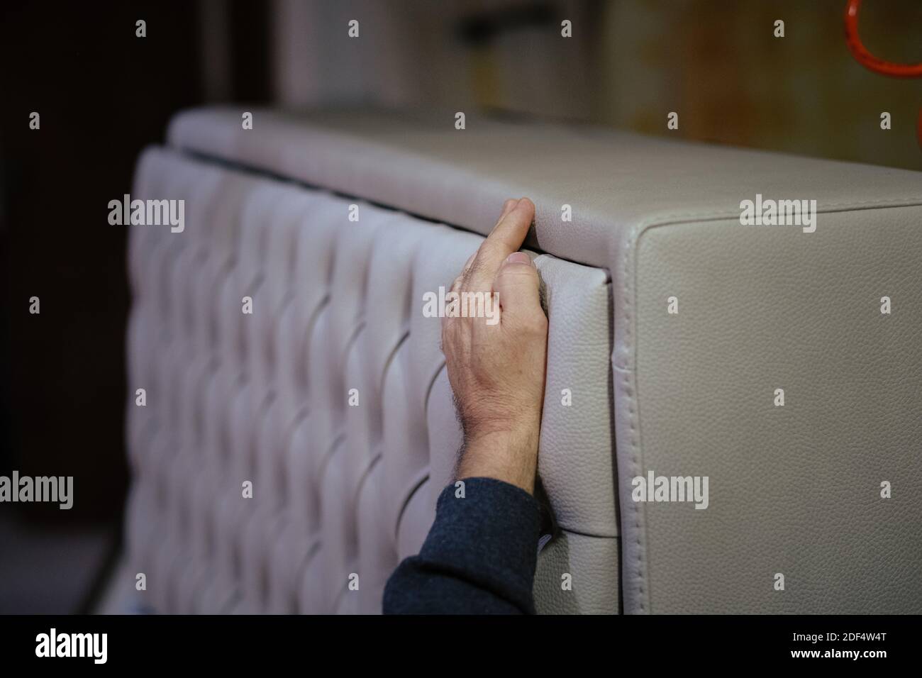 Un colpo closeup del lavoratore che installa la testata del letto con i rhinestones Foto Stock