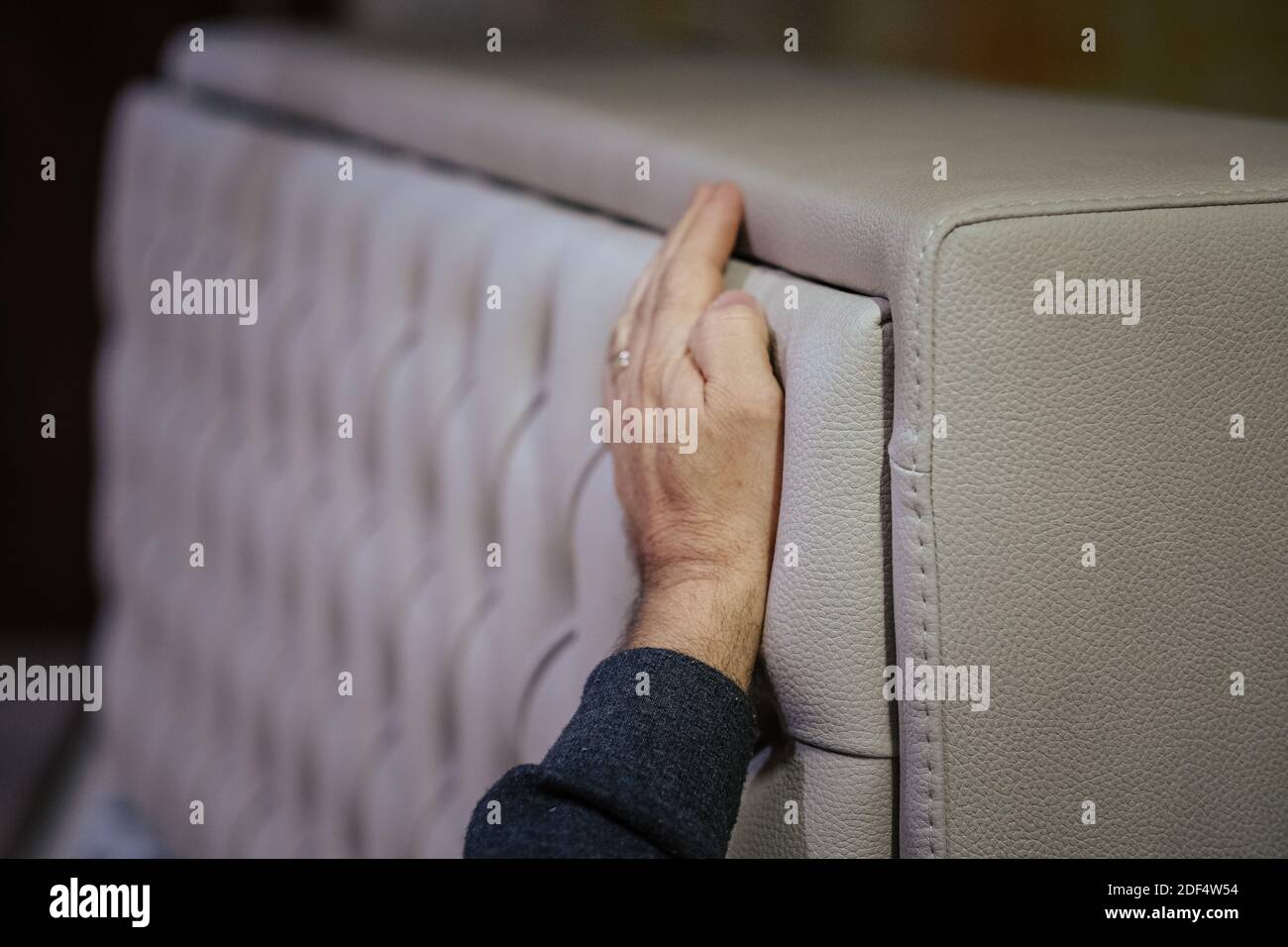 Un colpo closeup del lavoratore che installa la testata del letto con i rhinestones Foto Stock
