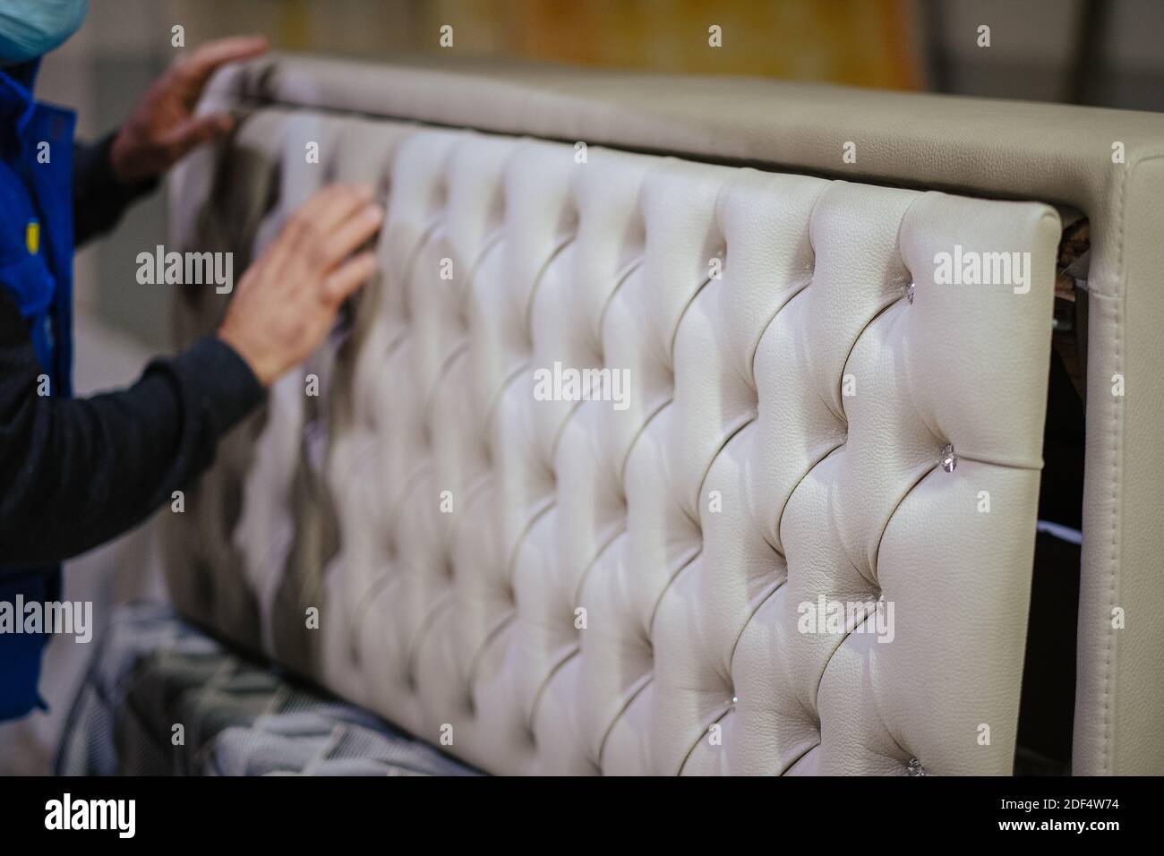 Un colpo closeup del lavoratore che installa la testata con i rhinestones Foto Stock