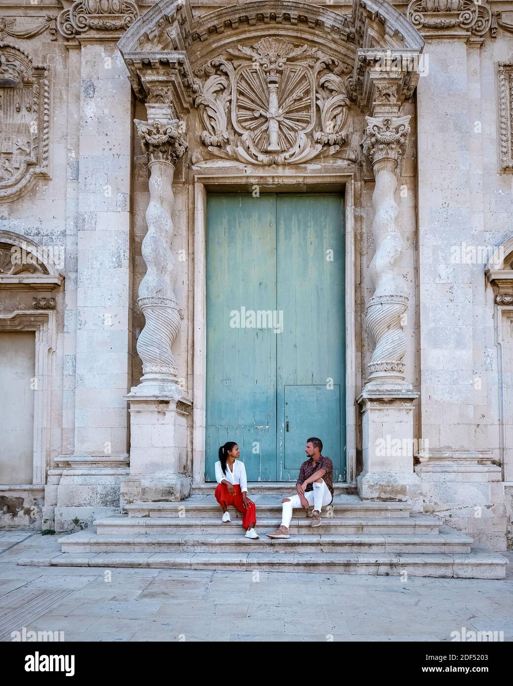 Coppia di uomini e donne in viaggio di città, Ortigia a Siracusa Sicilia Italia al mattino. Viaggi Fotografia da Siracusa, Italia sull'isola di Sicilia. Foto Stock