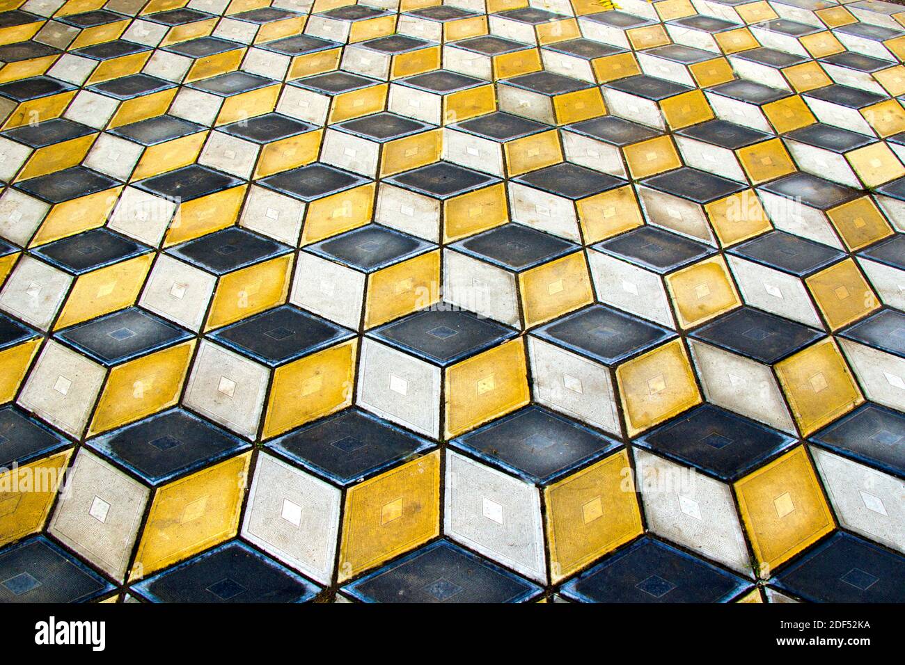 Geometria cubi pavimento ottico illusione nel parco di Tbilisi. Sfondo della figura geometrica. Giallo e nero. Foto Stock