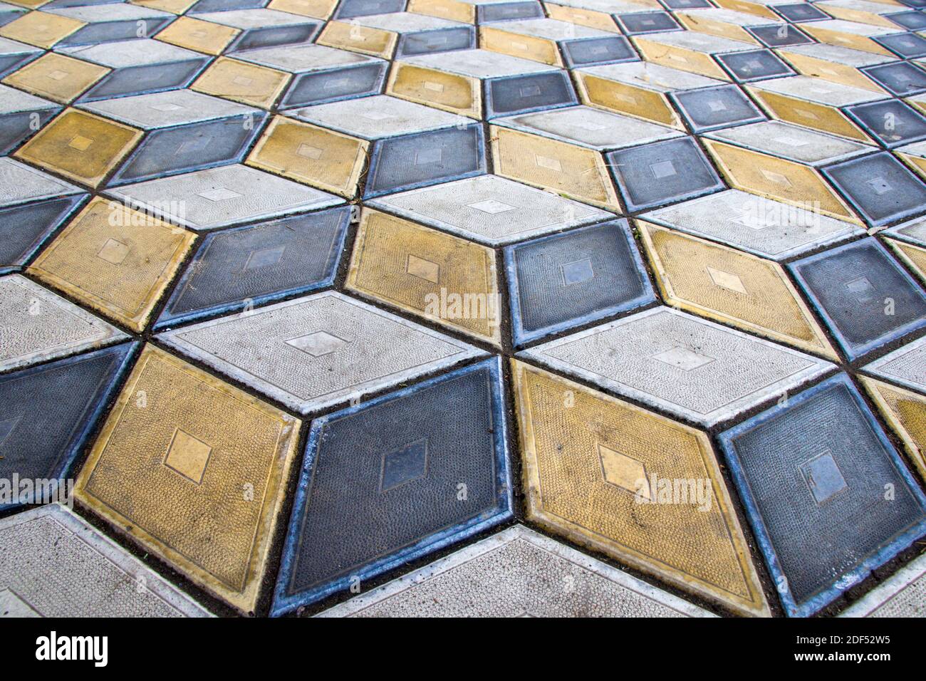 Geometria cubi pavimento ottico illusione nel parco di Tbilisi. Sfondo della figura geometrica. Giallo e nero. Foto Stock