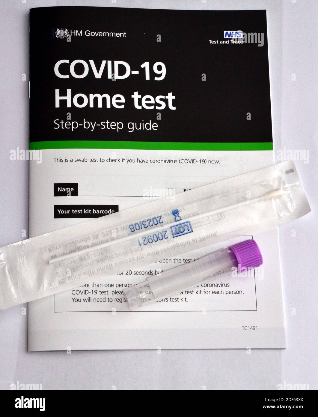 Un libretto di istruzioni per i test UK H M Government e NHS Covid 19 Home su cui è riportato il tampone di prova in un involucro e un flaconcino di plastica da utilizzare per la restituzione. Foto Stock