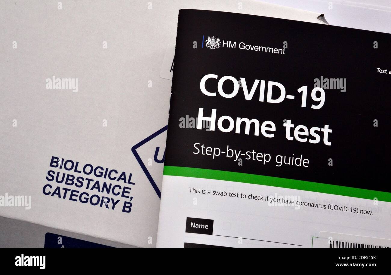 Un libretto di istruzioni per le prove in casa uk H M Government e NHS Covid 19 sulla scatola di cartone contrassegnata con "sostanza biologica" per la restituzione del campione di prova. Foto Stock