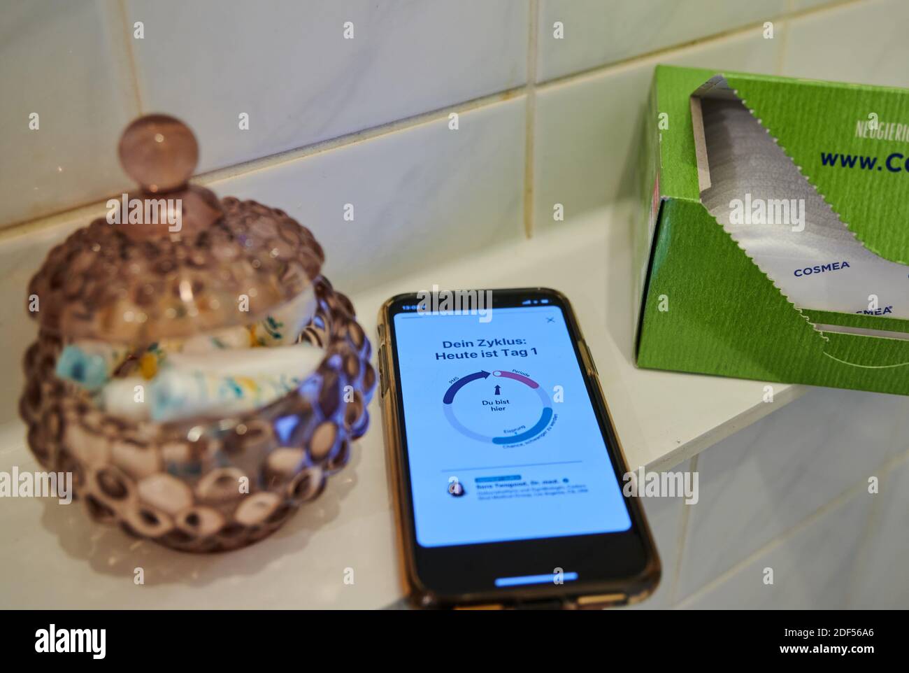 Berlino, Germania. 27 Nov 2020. Un'app per il ciclo su uno smartphone si trova in bagno accanto a rivestimenti per mutandine e un vasetto di tamponi. Credit: Annette Riedl/dpa/Alamy Live News Foto Stock