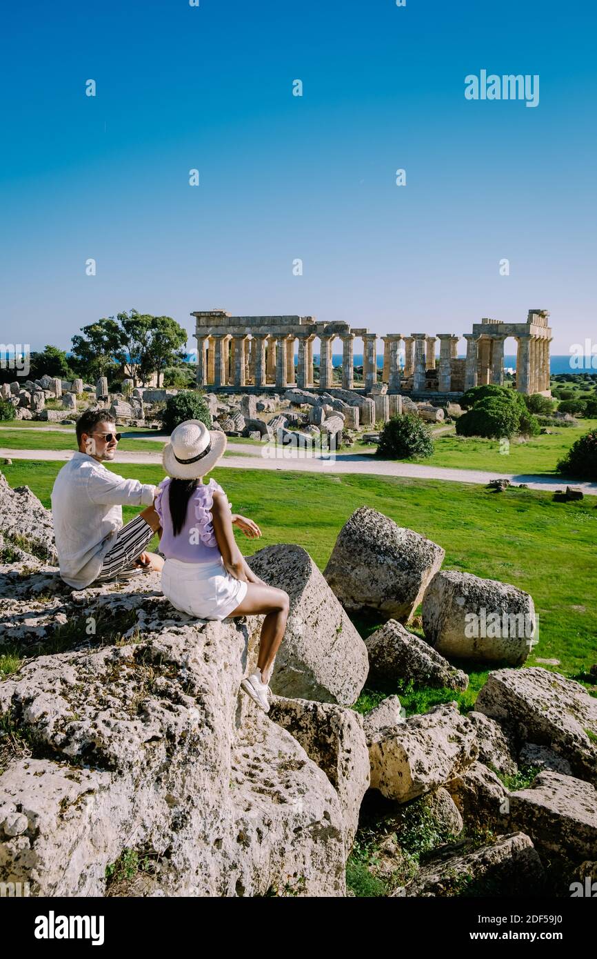 Una coppia visita templi greci a Selinunte durante le vacanze, vista sul mare e rovine di colonne greche nel Parco Archeologico Selinunte Sicilia Italia Foto Stock